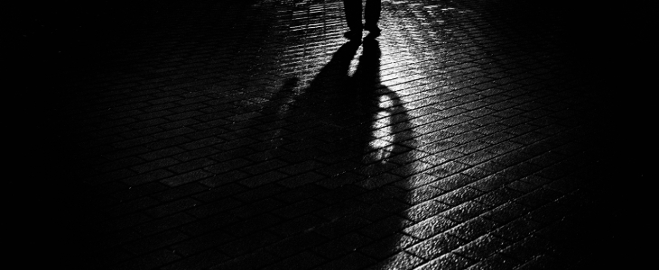 a person walking at night with their shadow on the brick road criminal defense civardi obiol